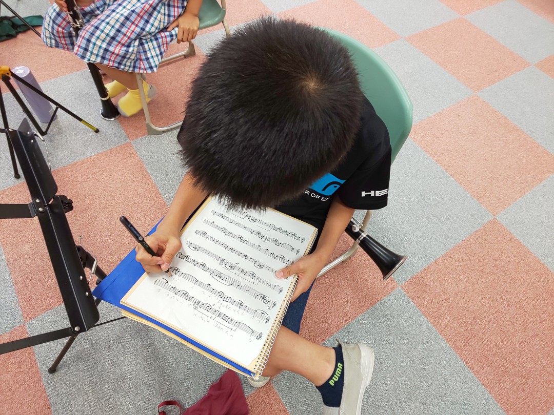 楽譜にドレミを書き込む小学生