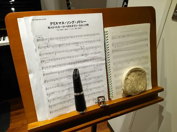 譜面台に置かれたクラリネットのパート譜とマウスピース