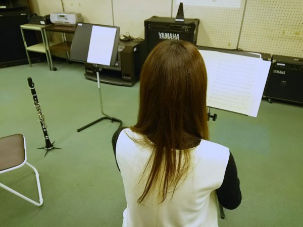 楽譜を見ながらクラリネットを練習する生徒