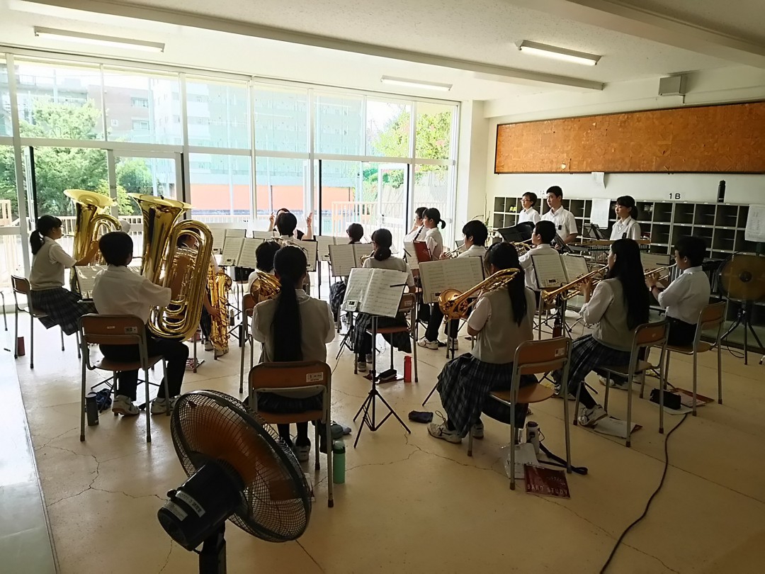 学校の教室で合奏する吹奏楽部
