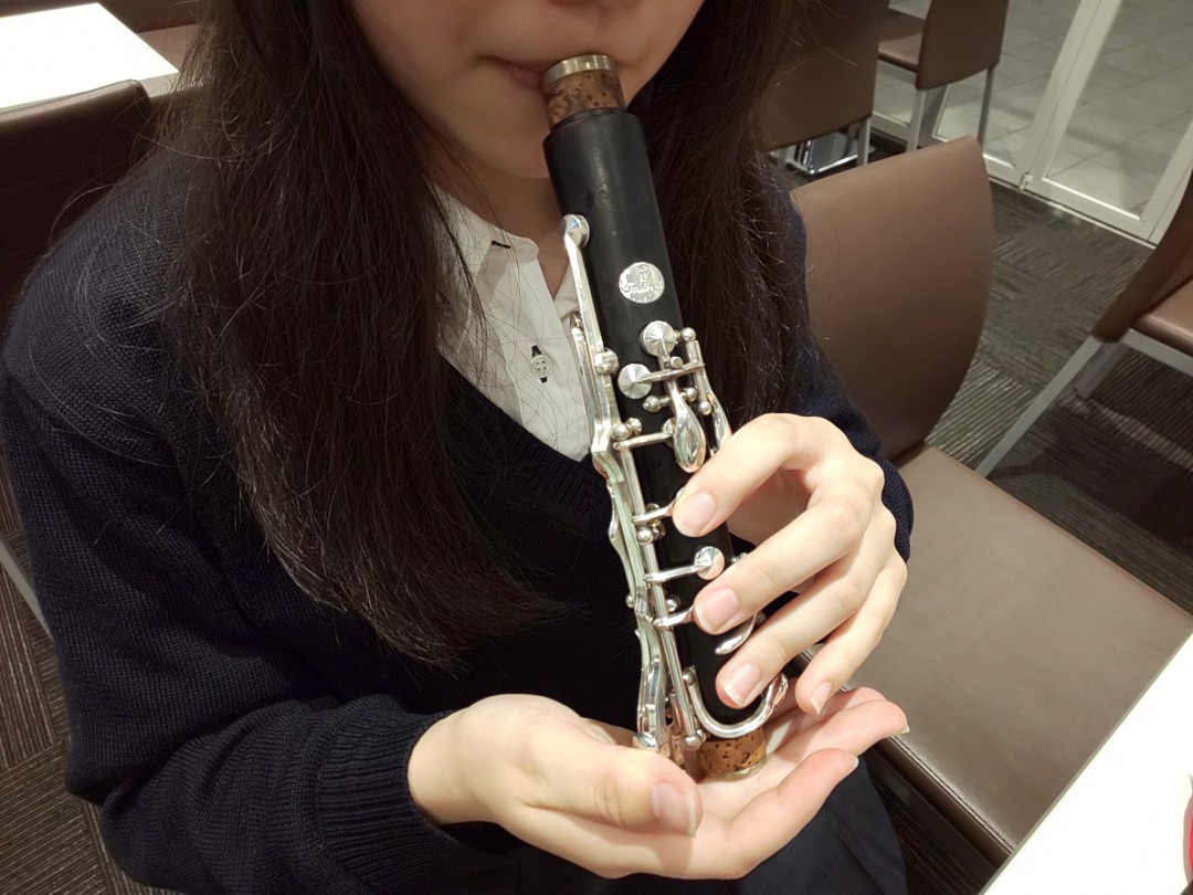 クラリネット上管の水分を取っている女性
