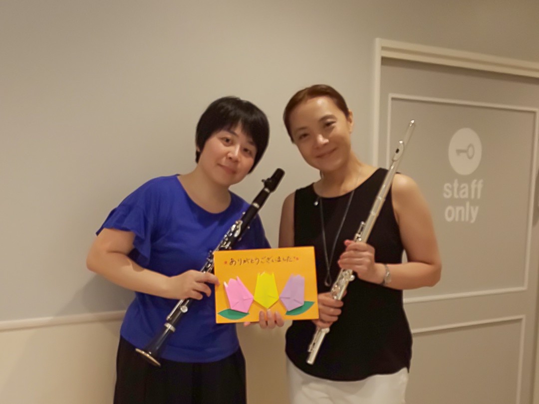 園児からもらった手作りのカードを持ったフルート奏者とクラリネット奏者
