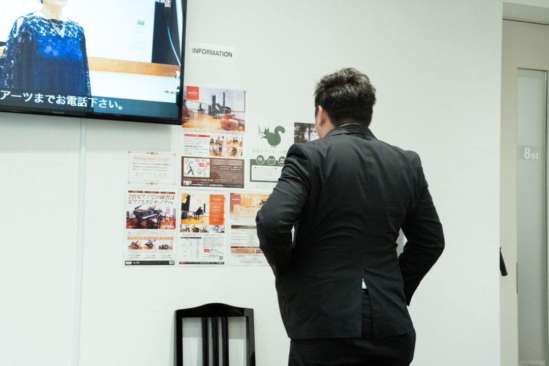 実技模試開始前に壁に貼られた教室のポスターを見る参加者