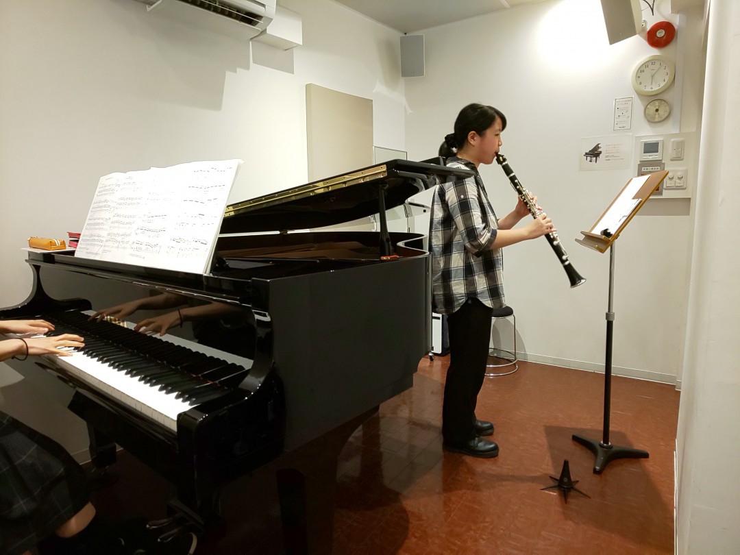 レッスンでピアニストと演奏する生徒