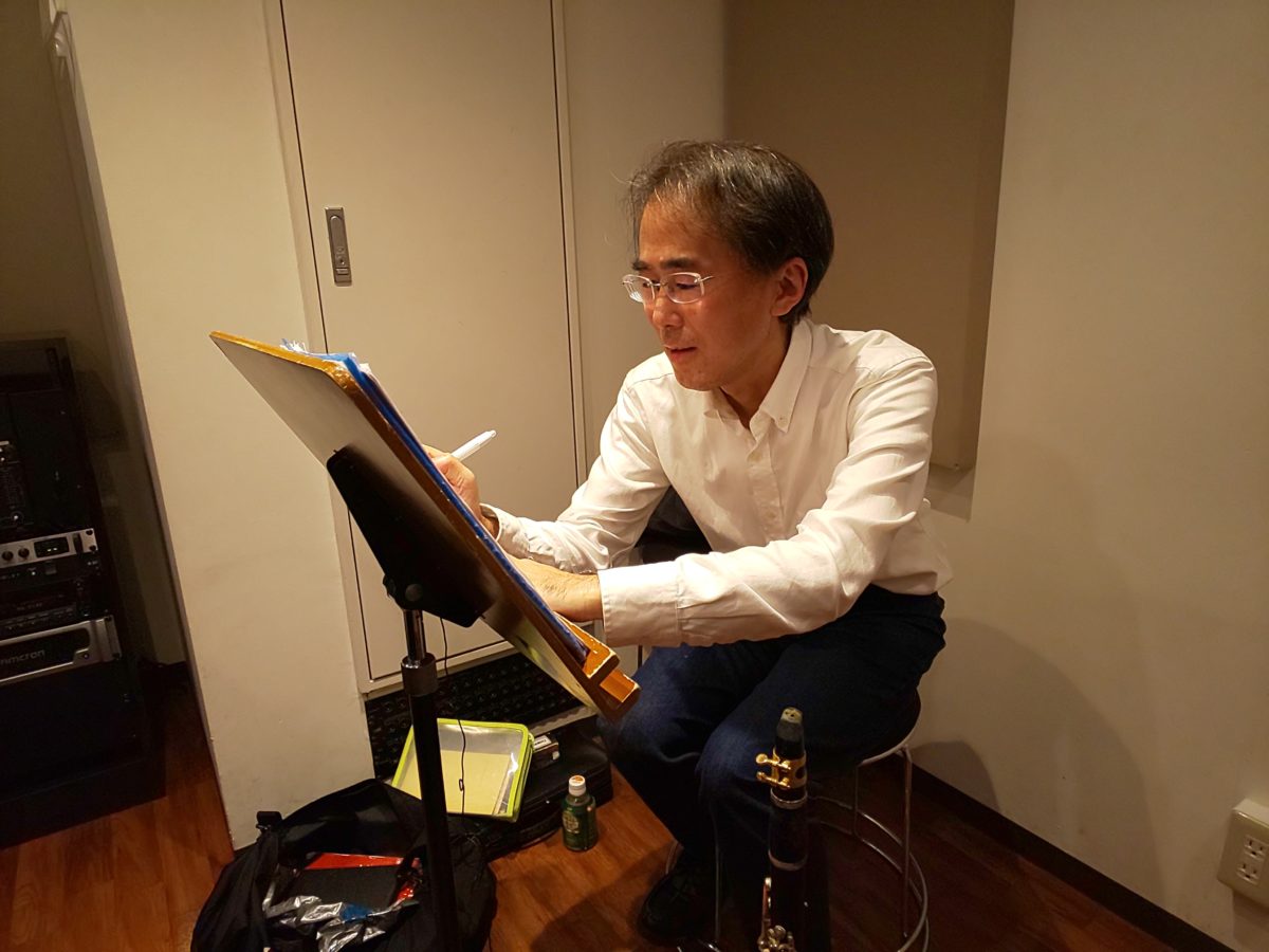 笑顔で楽譜に書き込みをする生徒