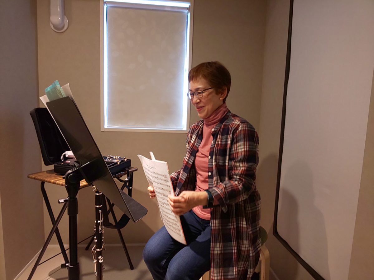 楽譜を持って笑顔で話をする生徒