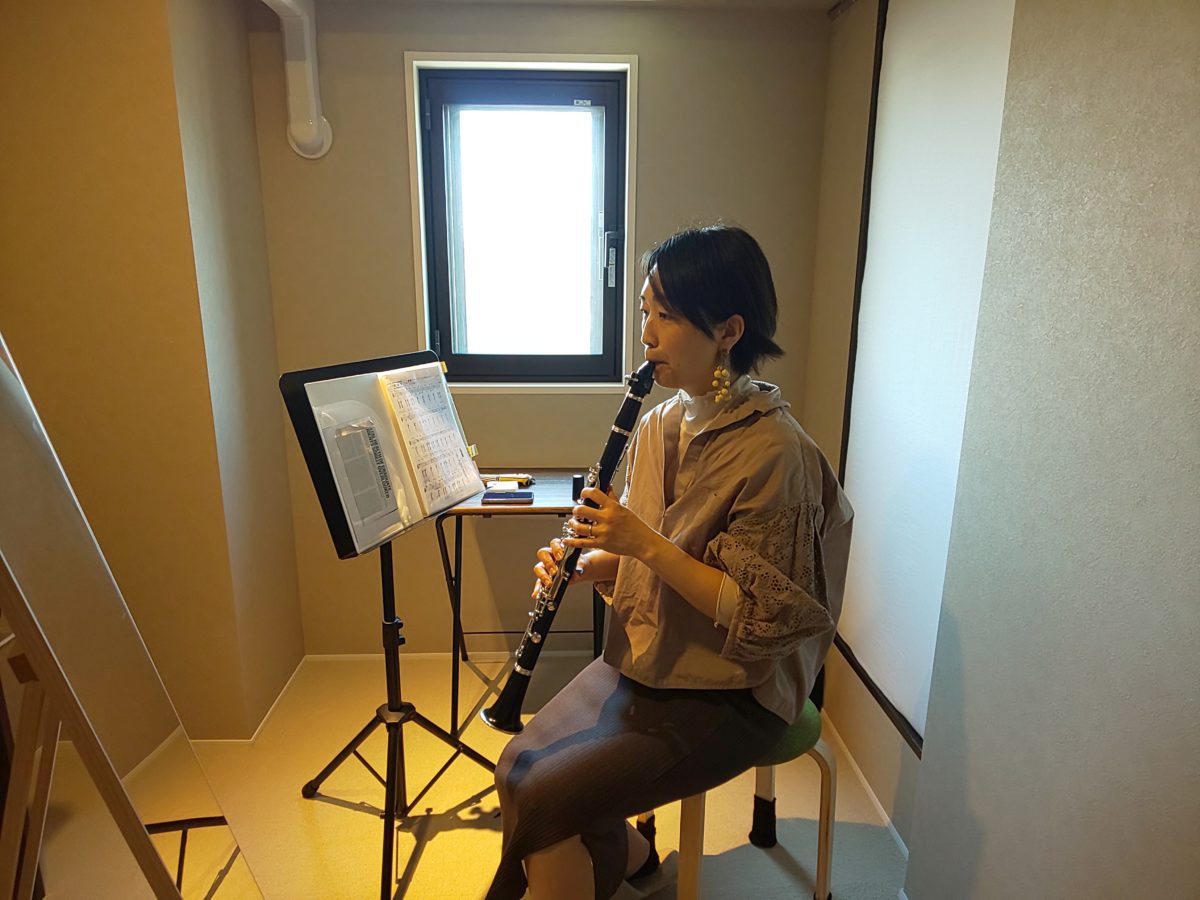 吹き方を鏡で確認しながら演奏する生徒