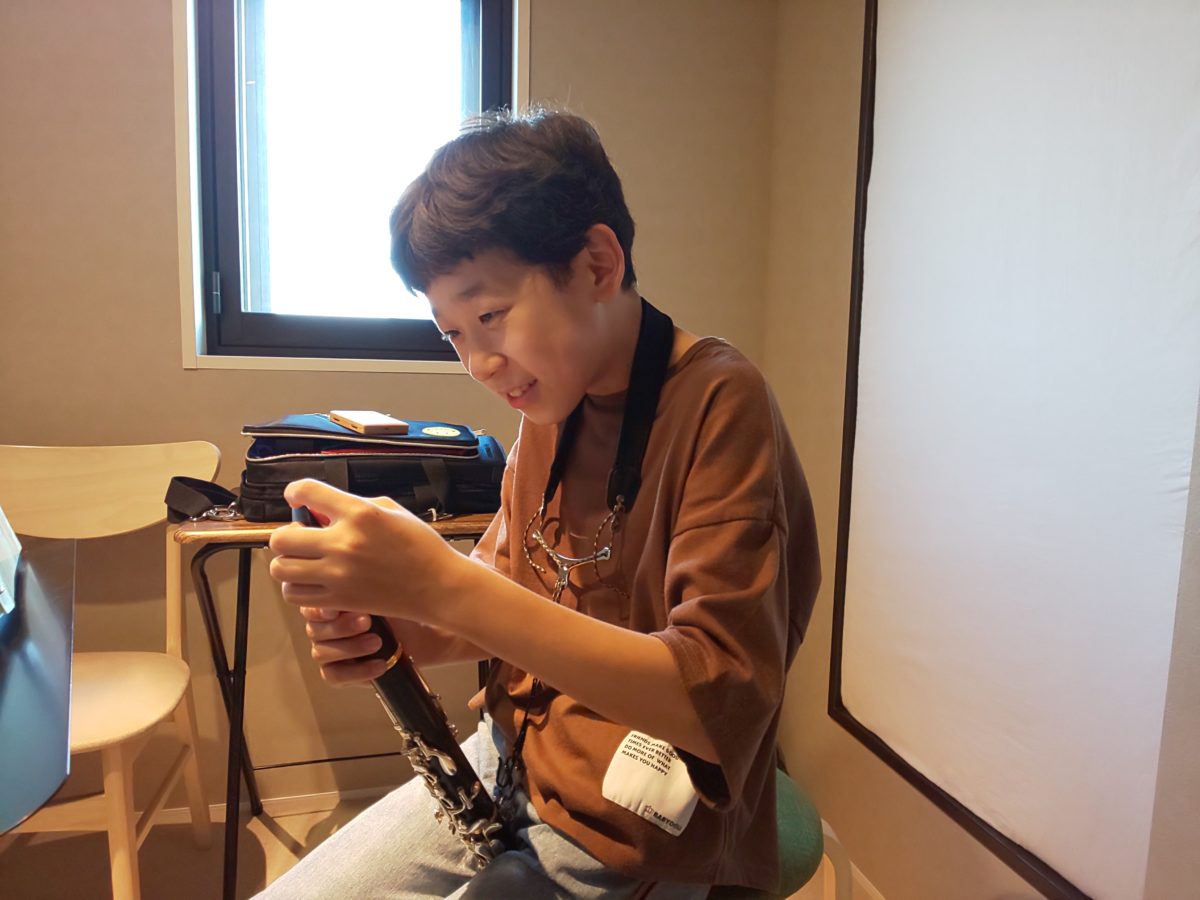 笑顔で講師と話しながらリード探しをする生徒