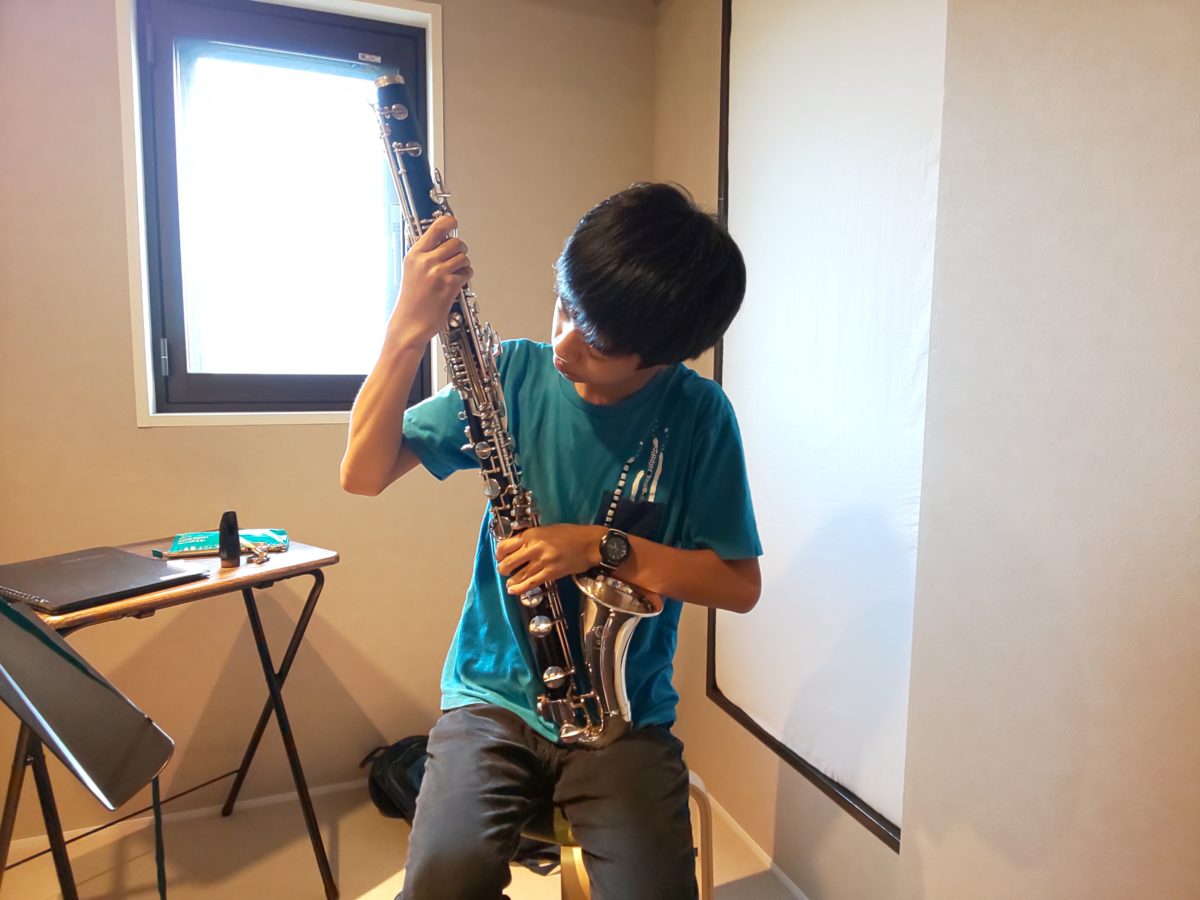 注意深くバスクラリネットを組み立てる生徒