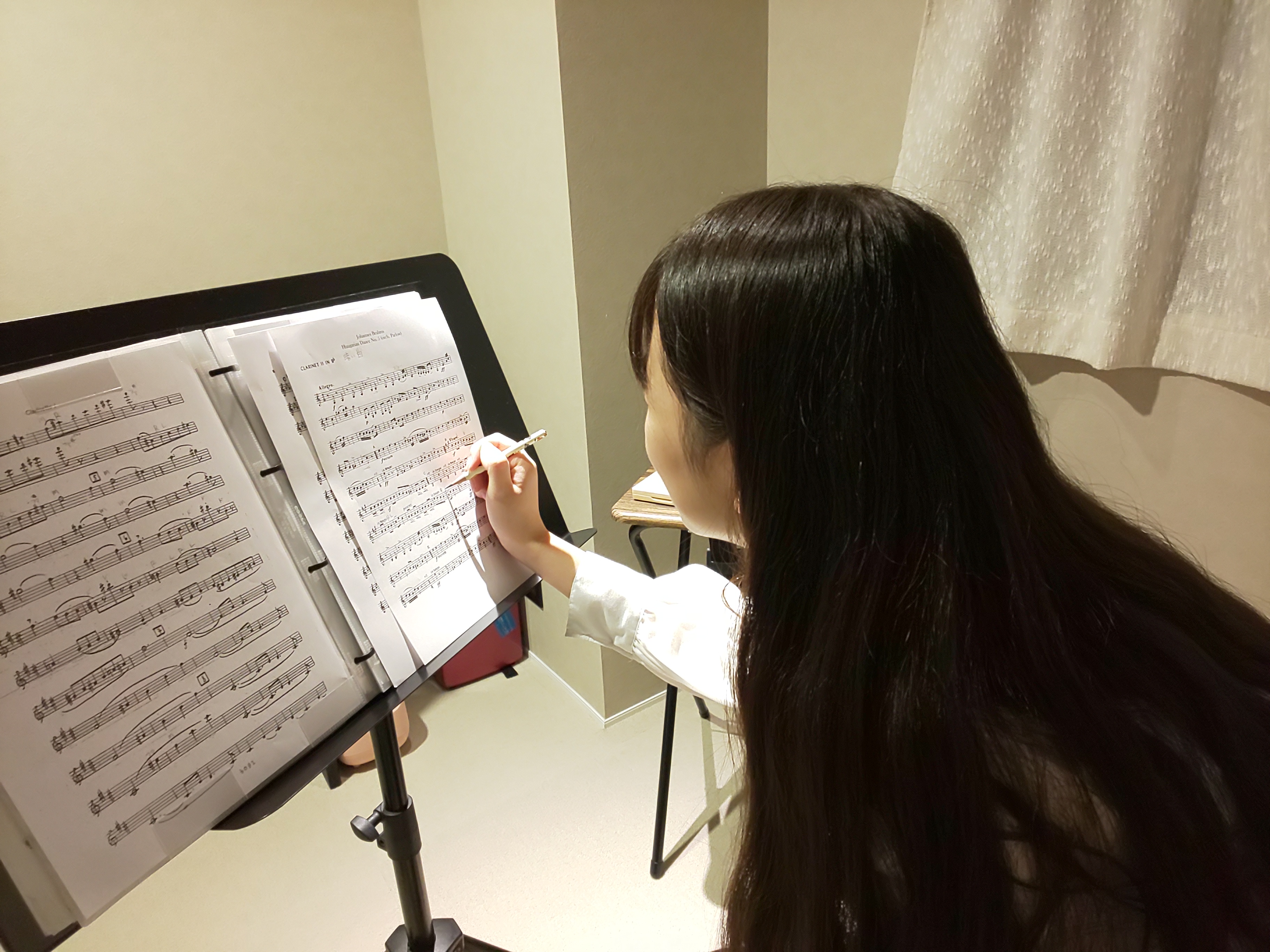 新曲がスムーズに吹けるように楽譜に書き込みをする生徒