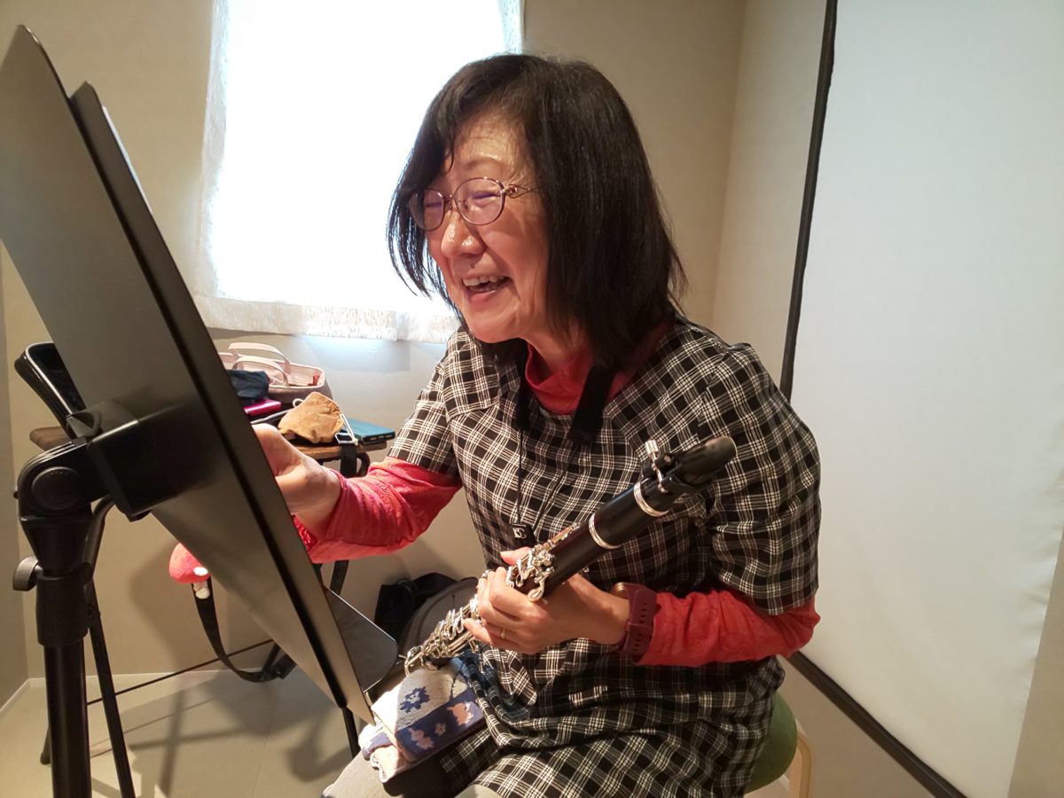 笑顔で楽譜を指差す生徒